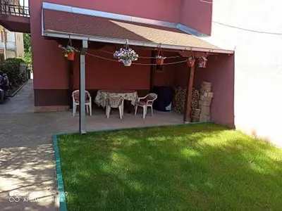 a patio with a table and chairs in a house at Apartman Mila in Niš