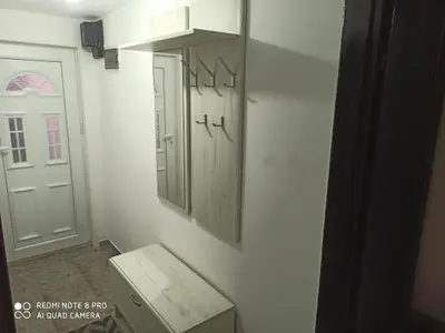 a bathroom with a sink and a mirror and a door at Apartman Mila in Niš