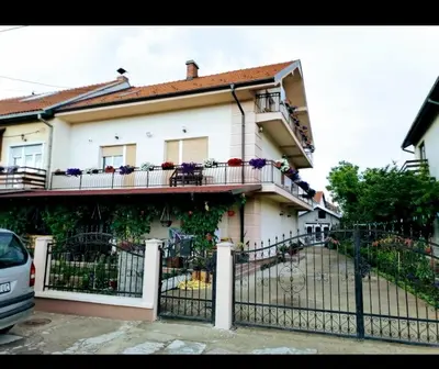 a white house with flowers on the balcony at Privatni smestaj - Grujic in Bujanovac