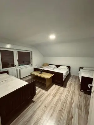 a room with two beds and a table in it at Privatni smestaj - Grujic in Bujanovac