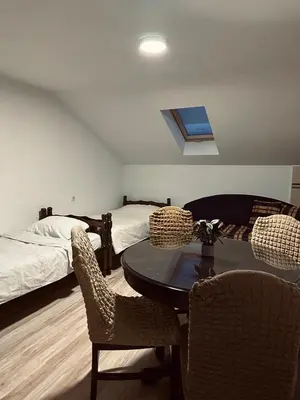 a room with a bed and a table and chairs at Privatni smestaj - Grujic in Bujanovac