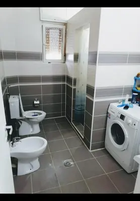 a bathroom with a toilet and a washing machine at Privatni smestaj - Grujic in Bujanovac