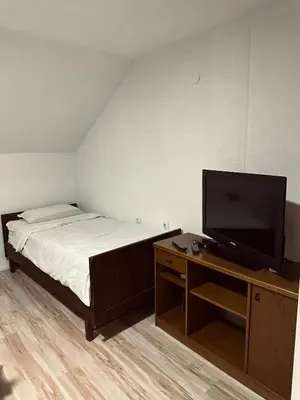 a bedroom with a bed and a flat screen tv at Privatni smestaj - Grujic in Bujanovac