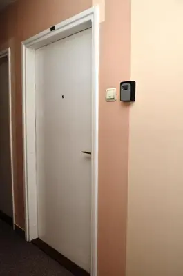 a white door with a clock on a wall at TIKE, TAK - Central Residence in Niš