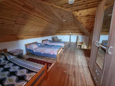 two beds in a room with wooden floors at Country House Sunčev breg in Bara Slatina
