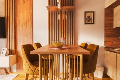 a dining room with a wooden table and chairs at Apartman 'Kapljica' in Vrnjačka Banja