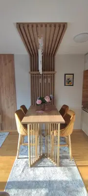a dining room table with chairs and a wooden table at Apartman 'Kapljica' in Vrnjačka Banja