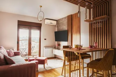 a living room with a couch and a table with chairs at Apartman 'Kapljica' in Vrnjačka Banja