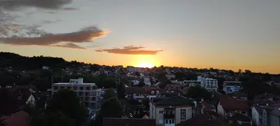 a view of a city with the sunset in the background at Apartman 'Kapljica' in Vrnjačka Banja