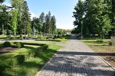 a brick path in a park with trees and grass at Apartman Lipa 11 in Vrnjačka Banja