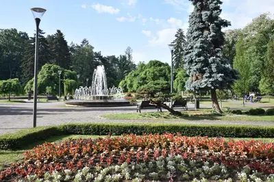 a fountain in a park with flowers in a park at Apartman Lipa 11 in Vrnjačka Banja