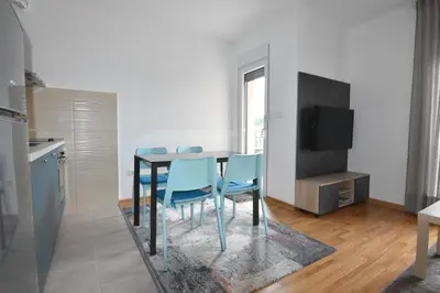 a kitchen and dining room with a table and blue chairs at Apartman Lipa 11 in Vrnjačka Banja