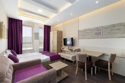 a hotel room with a bed and a dining room at Milmari K13 in Kopaonik