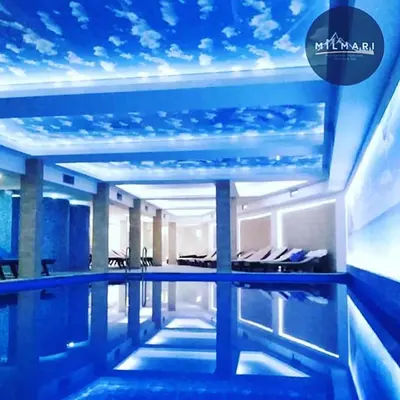 a swimming pool in a building with a blue ceiling at Milmari K13 in Kopaonik