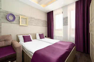 a hotel room with a bed and a chair at Milmari K13 in Kopaonik