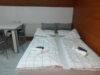 a large bed with white sheets and pillows on it at Apartman Ljiljan in Niš