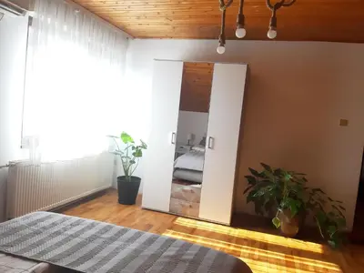 a bedroom with a mirror and a bed in a room at Apartman Ljiljan in Niš