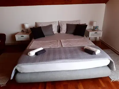 a bed in a bedroom with two nightstands and two tables at Apartman Ljiljan in Niš