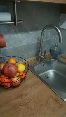a kitchen counter with a sink and a bowl of fruit at Studio apartman MarMar in Vrnjačka Banja