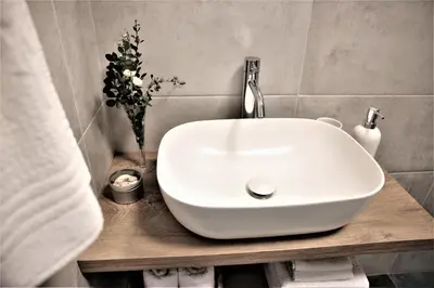 a white sink on a wooden counter in a bathroom at Studio apartman MarMar in Vrnjačka Banja