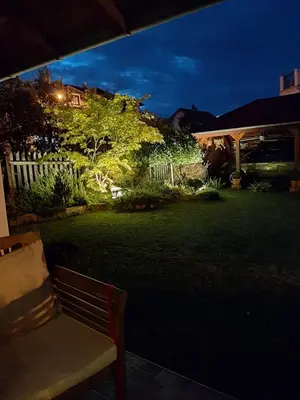 a bench sitting in a yard at night at Studio apartman MarMar in Vrnjačka Banja