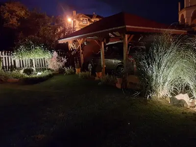 a car parked under a shed in a yard at night at Studio apartman MarMar in Vrnjačka Banja