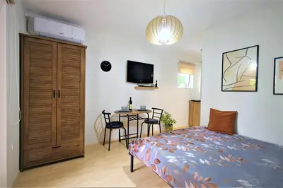 a bedroom with a bed and a table and a tv at Studio apartman MarMar in Vrnjačka Banja