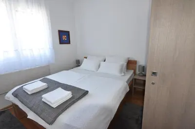 a bedroom with a white bed with two towels on it at Apartman Point in Vrnjačka Banja