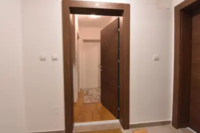 a hallway with a wooden door and a room at Apartman Point in Vrnjačka Banja