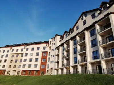 a row of apartment buildings with a green lawn at Apartman Sky Milmari L20 in Kopaonik