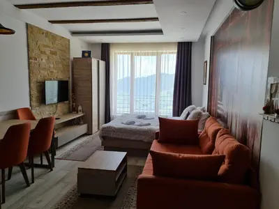 a living room with a couch and a bedroom at Apartman Sky Milmari L20 in Kopaonik