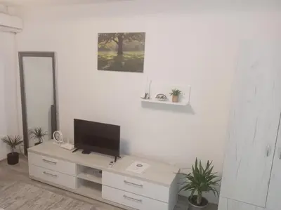 a living room with a tv on a white wall at Apartmani Nana in Vrnjačka Banja