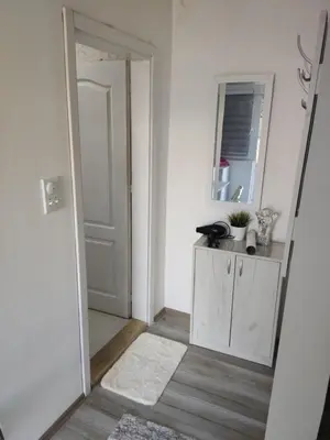 a white room with a door and a mirror at Apartmani Nana in Vrnjačka Banja