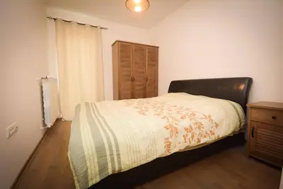 a bedroom with a bed and a wooden floor at Panorama LUX in Vrnjačka Banja