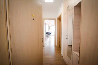 a hallway with a door leading to a room with chairs at Panorama LUX in Vrnjačka Banja
