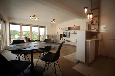 a kitchen and living room with a table and chairs at Panorama LUX in Vrnjačka Banja