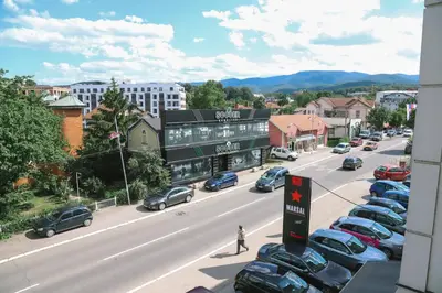 a city street with cars parked in a parking lot at Panorama LUX in Vrnjačka Banja