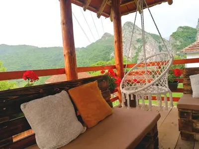 a porch with a swing and two chairs and a view at Konak Jerma-Kanjon Jerme Pirot in Pirot