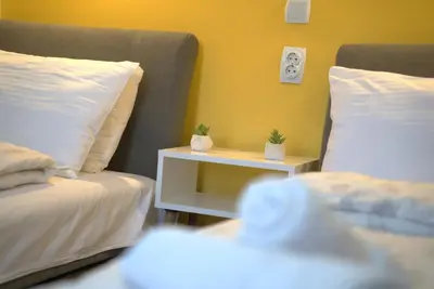 a bedroom with two beds and a night stand with a nightstand between them at Vila Storia in Niš