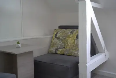 a black chair sitting next to a table with a pillow at Vila Storia in Niš