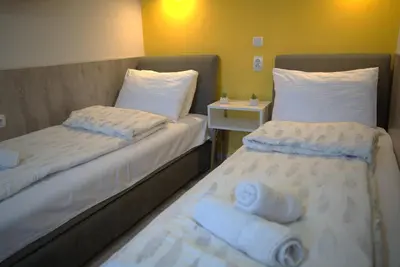 two beds sitting next to each other in a room at Vila Storia in Niš