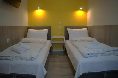 two beds in a hotel room with towels on them at Vila Storia in Niš