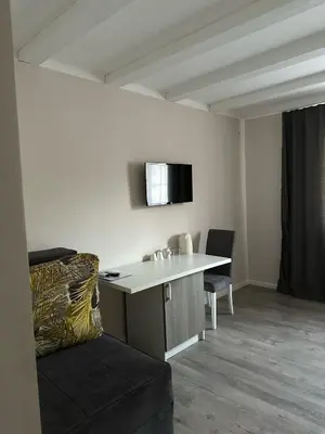a room with a desk and a chair and a tv at Vila Storia in Niš