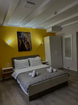 a bedroom with a large bed with two towels on it at Vila Storia in Niš