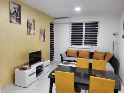 a living room with a table and a couch at Apartman Miloš in Soko Banja