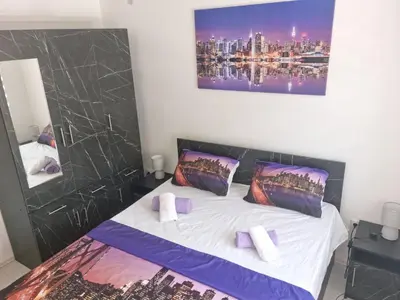 a bedroom with a large bed with purple pillows at Apartman Miloš in Soko Banja