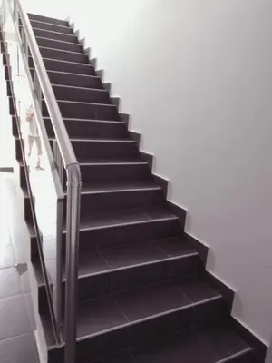 a staircase with black steps and a railing at Apartman Miloš in Soko Banja