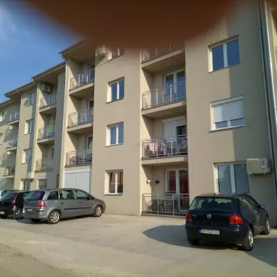three cars parked in a parking lot in front of a building at Apartman Miloš in Soko Banja