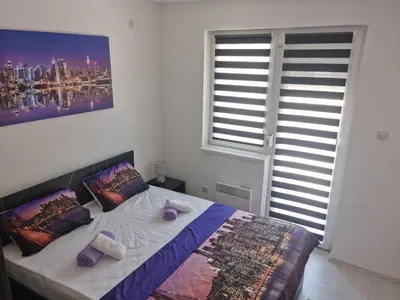 a bedroom with a bed with pillows and a painting on the wall at Apartman Miloš in Soko Banja