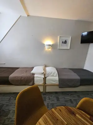 a hotel room with two beds and a table and chairs at NevSki Apartments in Kopaonik